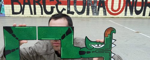 Portrait de l'artiste graffeur Oré devant un lettrage graffiti à Barcelone.