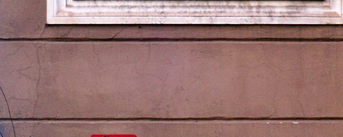 Œuvre street art de l'artiste graffeur Oré. Serpent à plumes, Quetzalcóatl, collé à Rome. Tableau rouge et blanc.