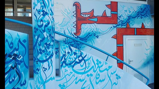 Détail d'une fresque street art de l'artiste graffeur Oré. Elle montre de la calligraphie arabe avec des serpents à plumes.