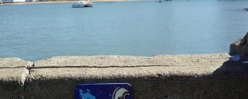 Œuvre street art de l'artiste graffeur Oré. Serpent à plumes, Quetzalcóatl, collé sur les quais de San Francisco. Downtown San Francisco dans le fond.