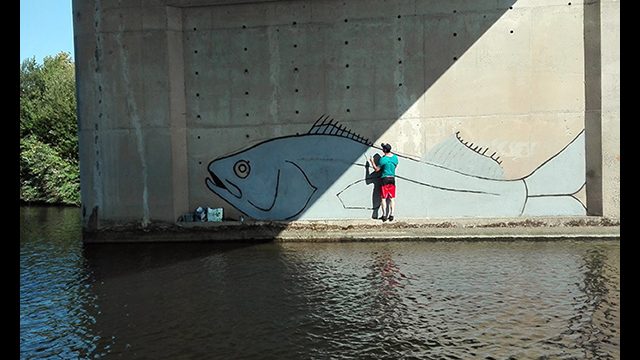 Poisson géant peint au milieu de la rivière. Fresque de l'artiste graffeur Oré.