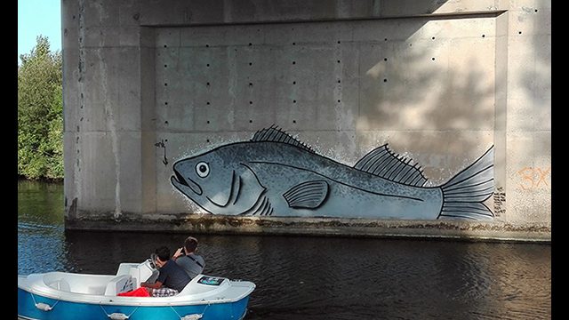 Poisson géant peint au milieu de la rivière. Par l'artiste graffeur Or
