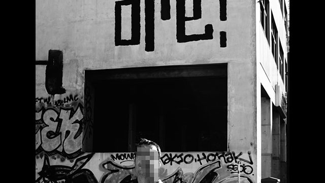 Lettrage graffiti Oré peint dans Athènes en Grèce. L'artiste pose devant le mur.