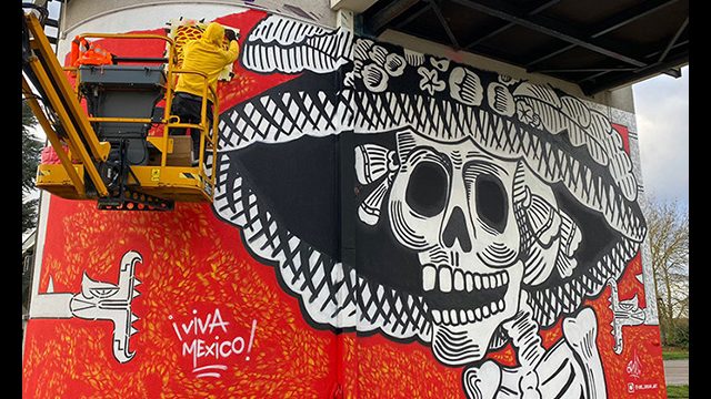 Fresque street art de l'artiste graffeur Oré sur l'autoroute A13 en Normandie. Elle représente une calavera mexicaine avec 2 serpents à plumes Quetzalcóatl.