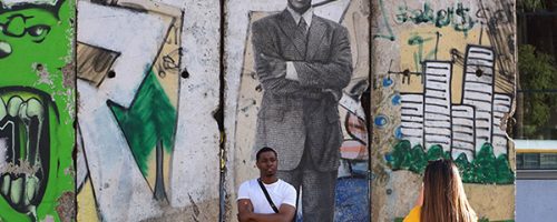 Portrait de Nelson Mandela avec un serpent à plumes de l'artiste graffeur Oré. Avec d'autres graffitis. Sur une section du mur de Berlin à Los Angeles. Avec un jeune noir pris en photo devant le mur.